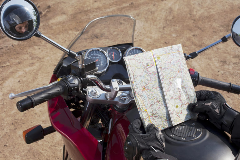 Motorradfahrer schaut auf eine Straßenkarte