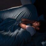 Junger Mann nachts im Bett